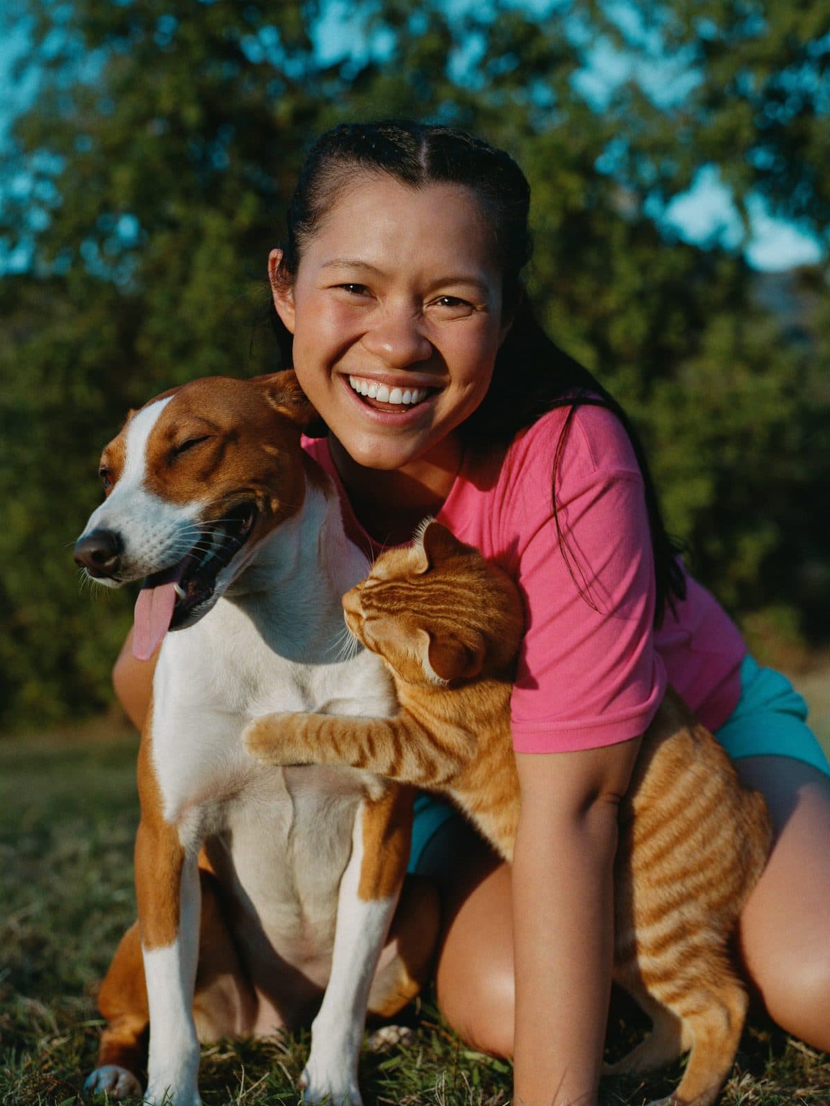 Voluntaria de Colitas Coclé sonriendo junto a un perro y un gato rescatados